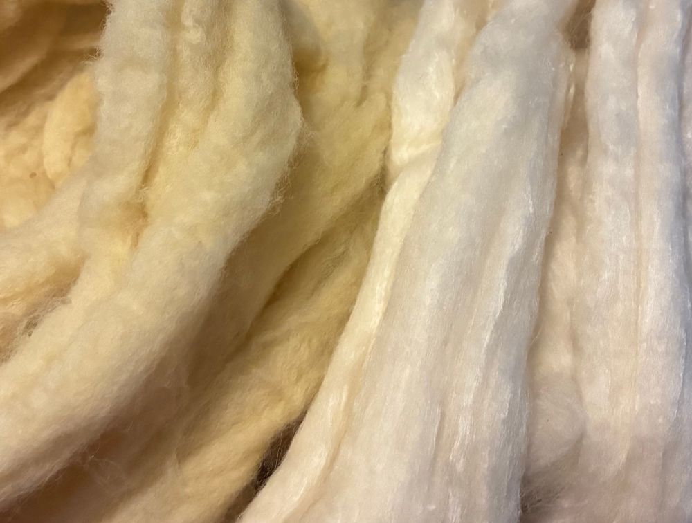 Final result on left in a light, buttery yellow compared to a white skein of undyed bamboo/wool blend on right.