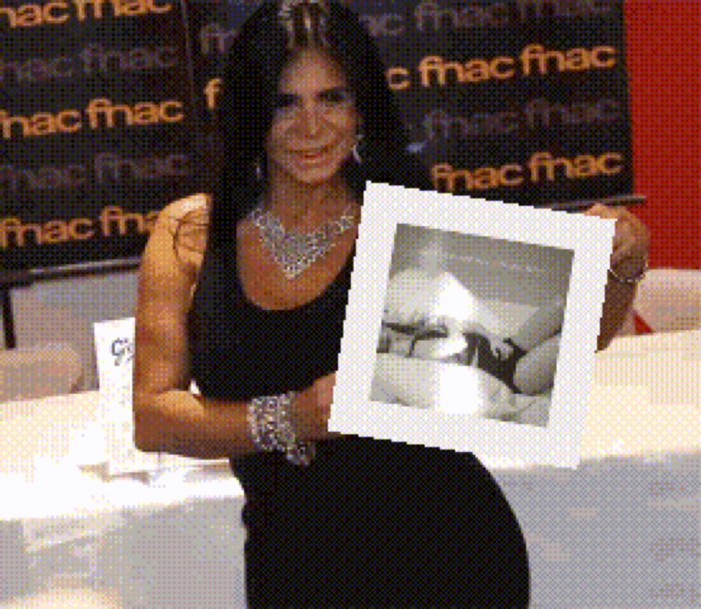 a woman in a black dress is holding a framed photo in front of a sign that says fnac