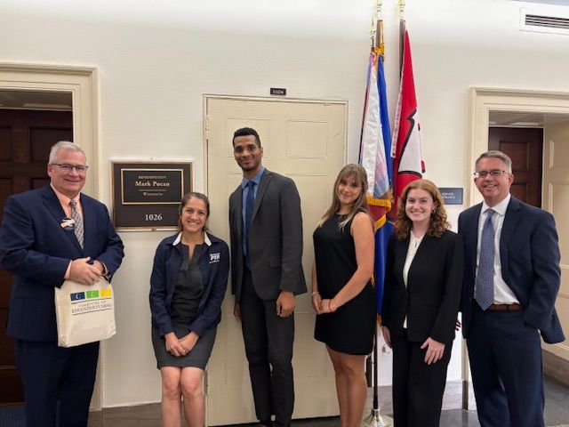 Picture of ALA staff member Kevin Maher posing in front of Representative Mark Pocan's office on Capitol Hill with other education funding advocates.