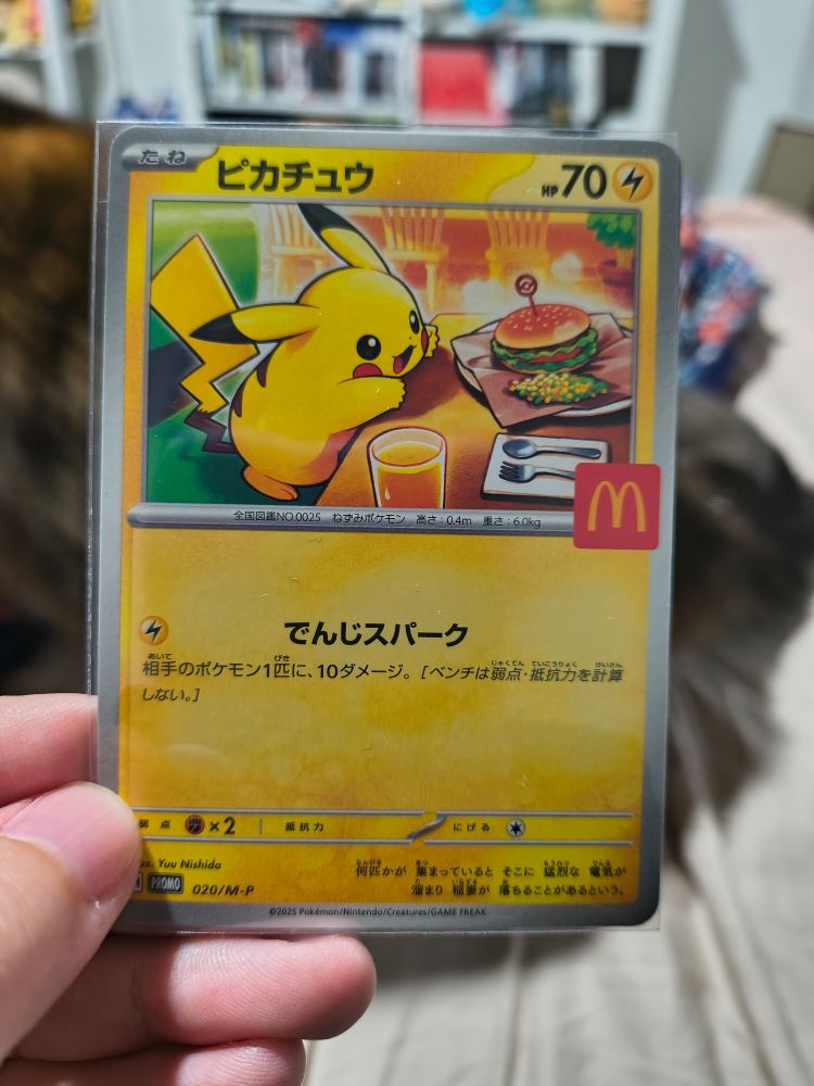 A photo of a Pikachu card from the Pokemon TCG featuring Pikachu eating a McDonald's burger.