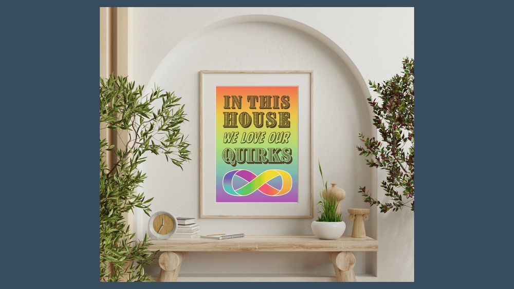A rainbow poster which reads 'in this house we love our quirks', with the rainbow infinity symbol underneath.