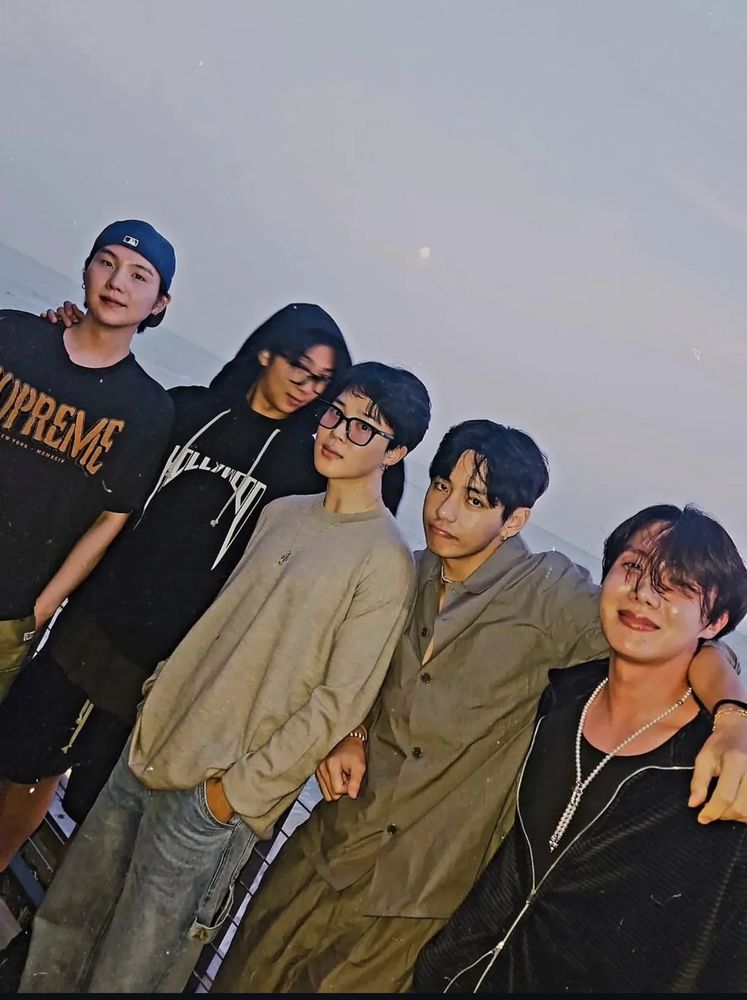 Yoongi, Namjoon, Jimin, Taehyung, and Hobi on a pier.