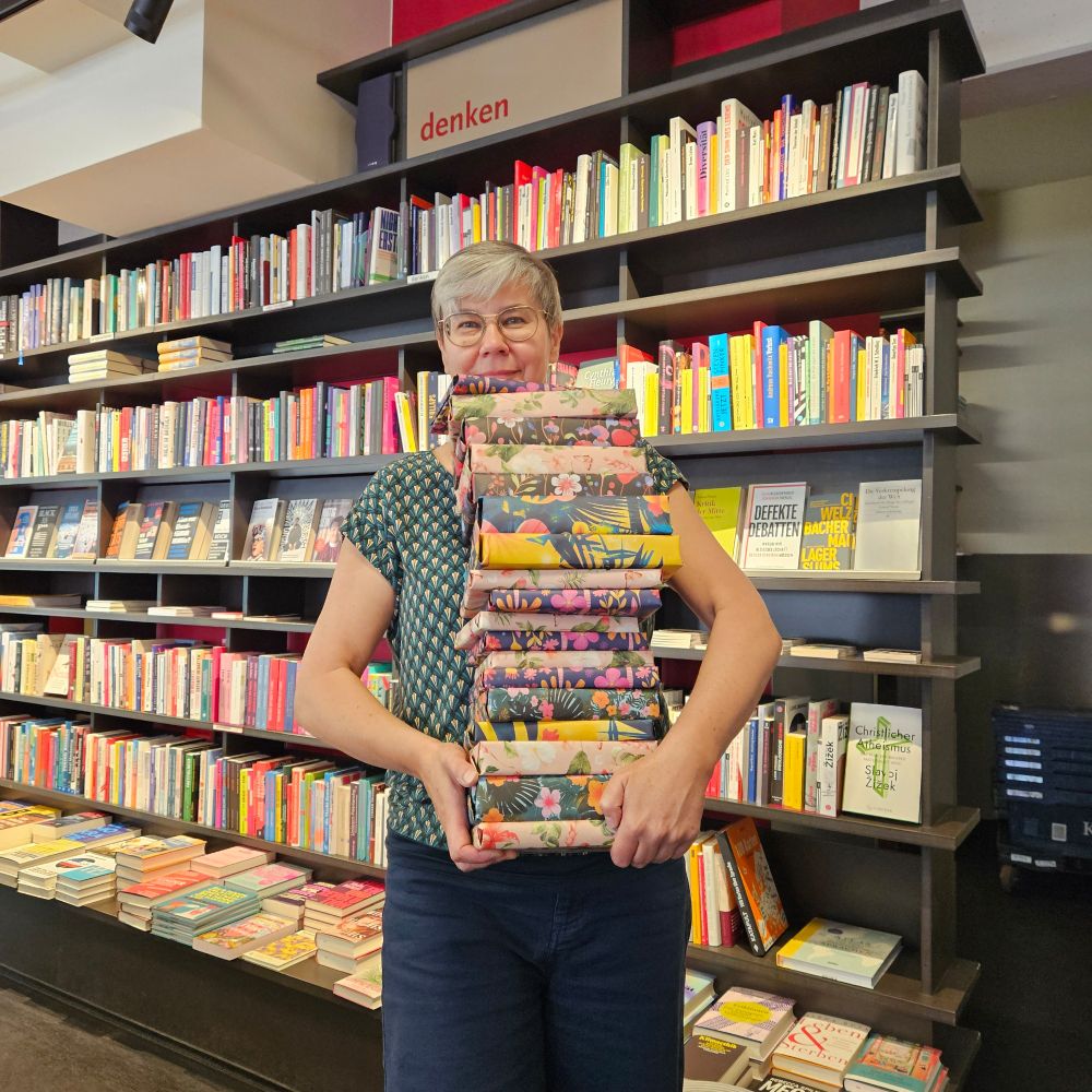Frau mit riesigem Bücherstapel