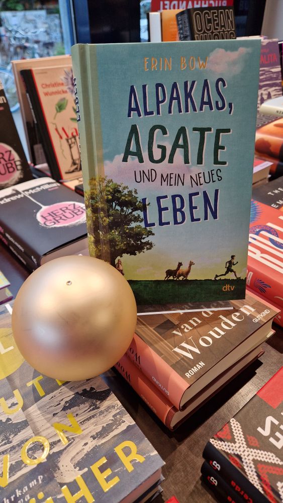 Hier steht unser Buchtipp ALPAKAS, AGATE UND MEIN NEUES LEBEN prachtvoll präsentiert neben einer Perle.