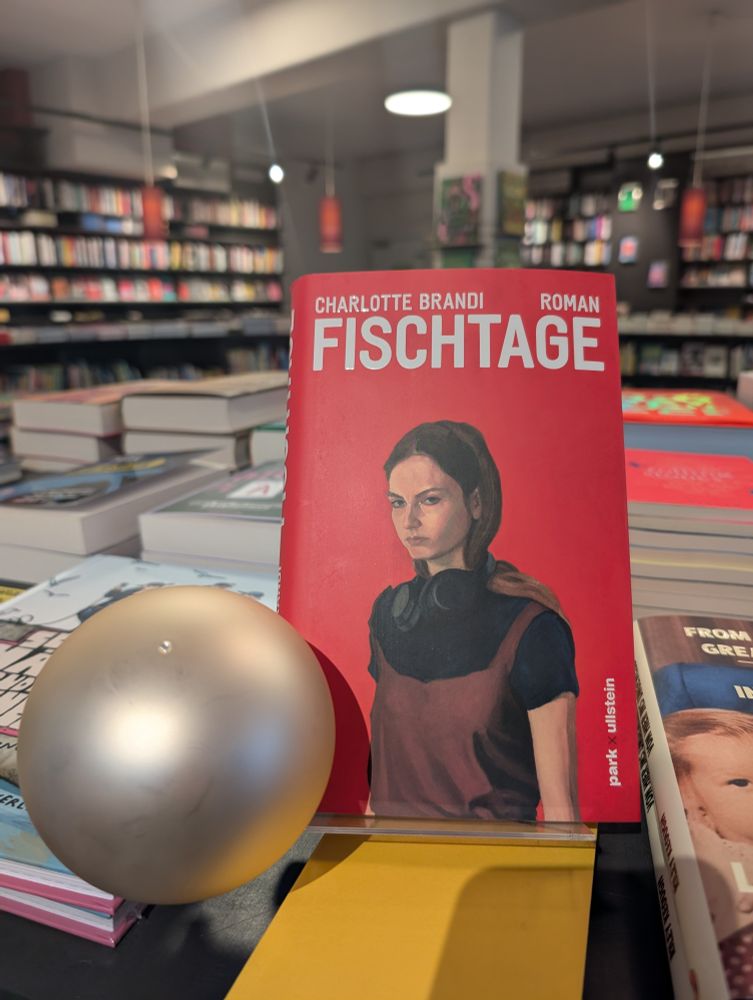 1 heißer Buchtipp: Charlotte Brandis grandioser Roman FISCHTAGE liegt hier im Scheinwerferlicht neben einer Perle.