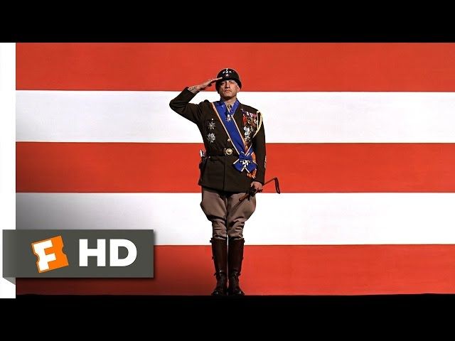 Patton in front of an American flag showing the red/white stripes from the movie