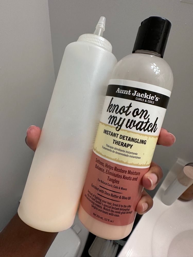 Close up of a bottle of aunt Jackie’s knot on my watch detangling conditioner and a mixing bottle 
