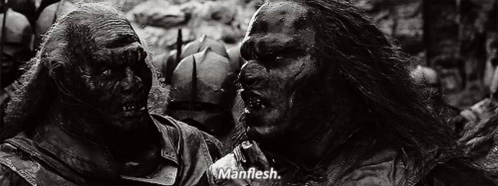 two orcs are standing next to each other in a black and white photo and one of them is saying `` manflesh '' .