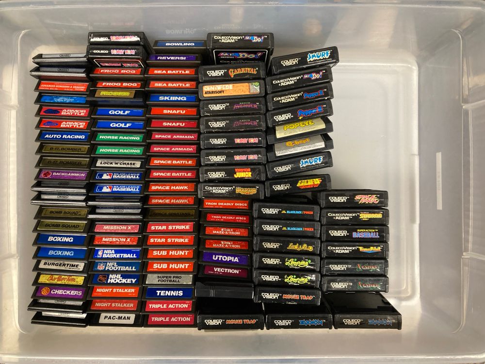 A bunch of Intellivision and ColecoVision game cartridges in a large plastic bin