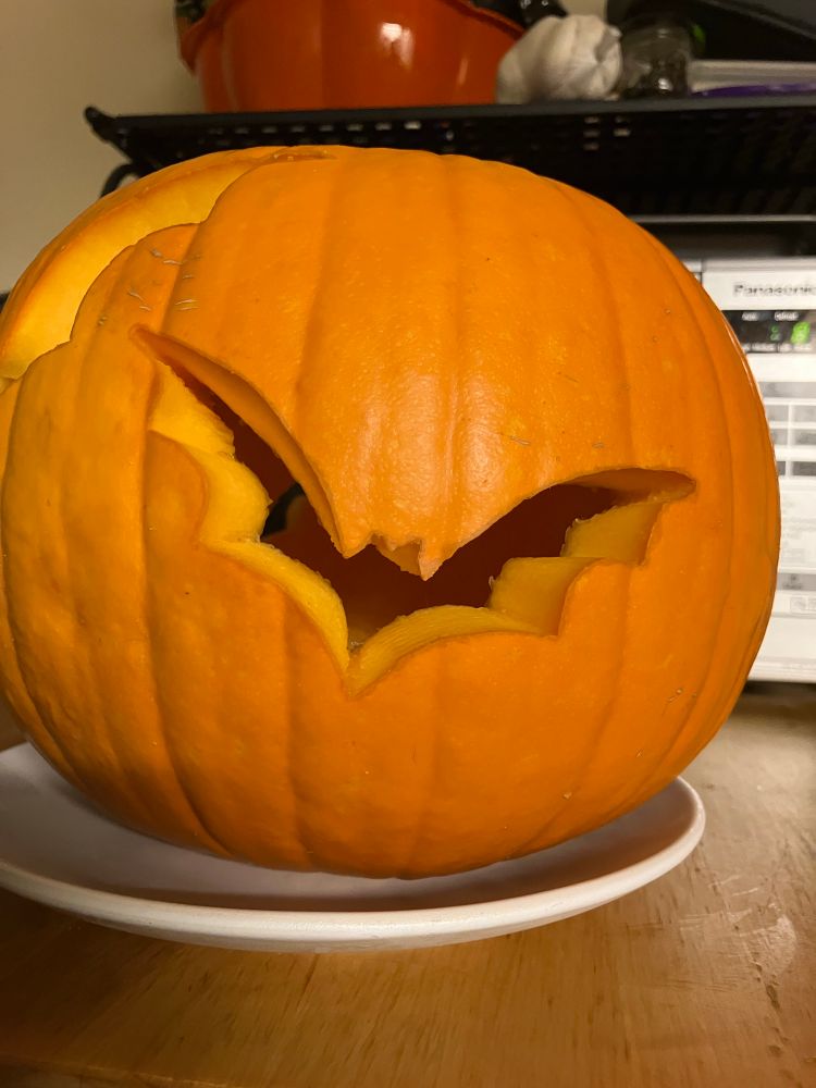 A smaller bat carved out in a pumpkin.