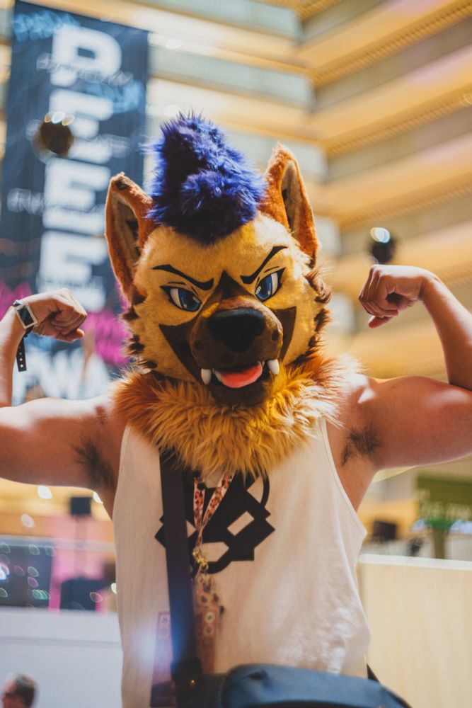 Koro flexing in front of the camera with the FWA PEEE sign at the background 