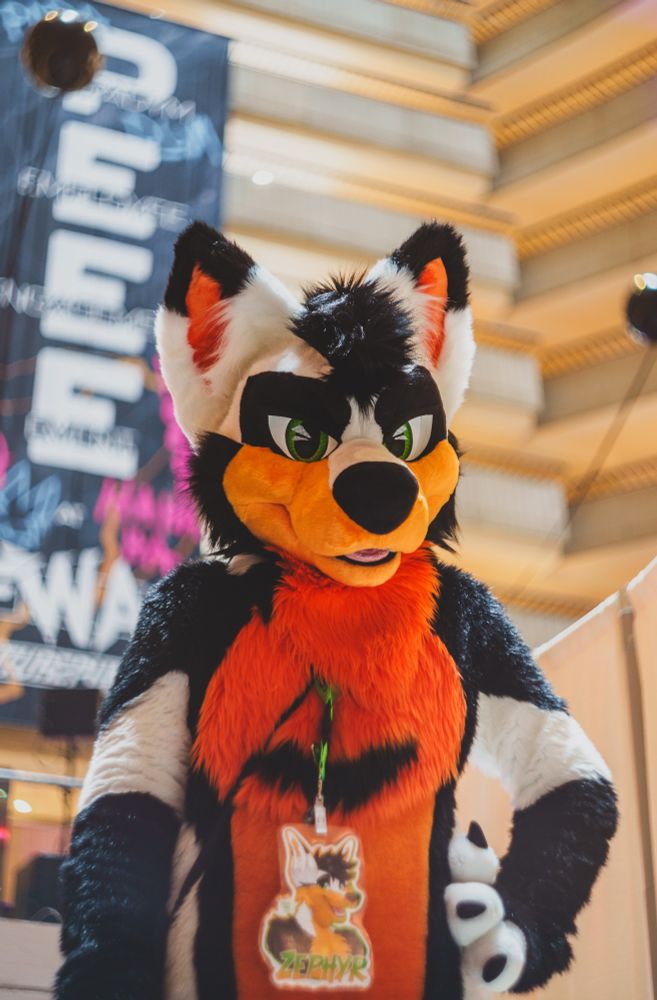 Zephyr looking at the camera with one hand on the hip with the FWA PEEE sign at the back