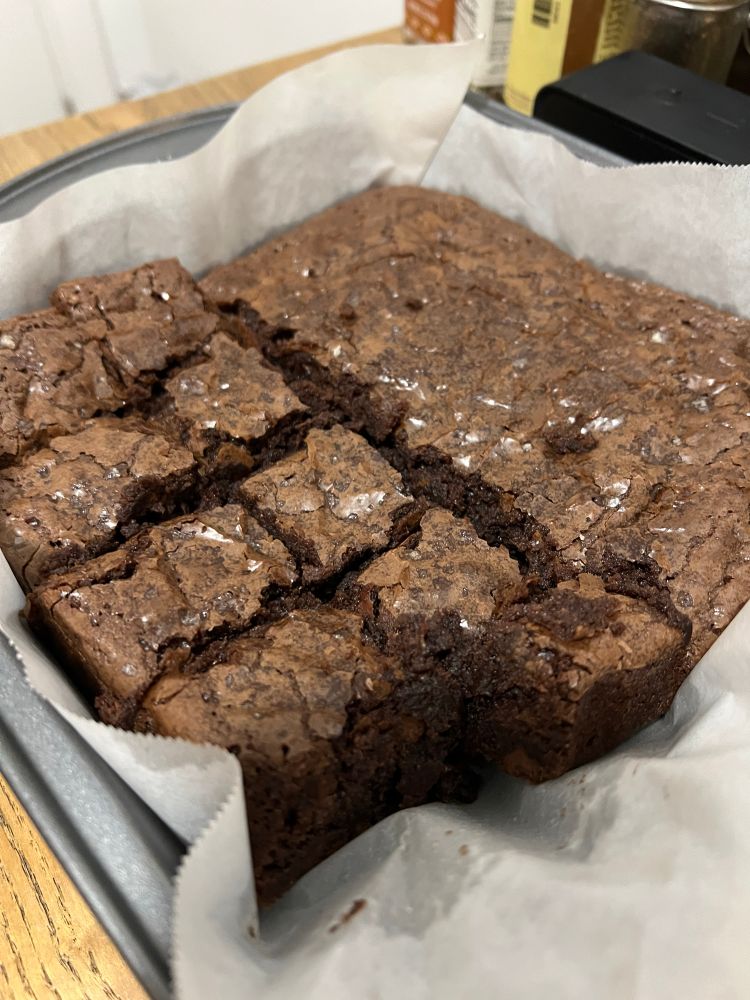 Fudgy brownies in a pan, still warm from the oven. The top is crinkly and appealing. 