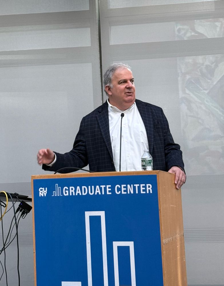President Brumberg kicking off the Black, Race, and Ethnic Studies Research Symposium in the Graduate Center Skylight room. He is speaking behind a Graduate Center branded podium.