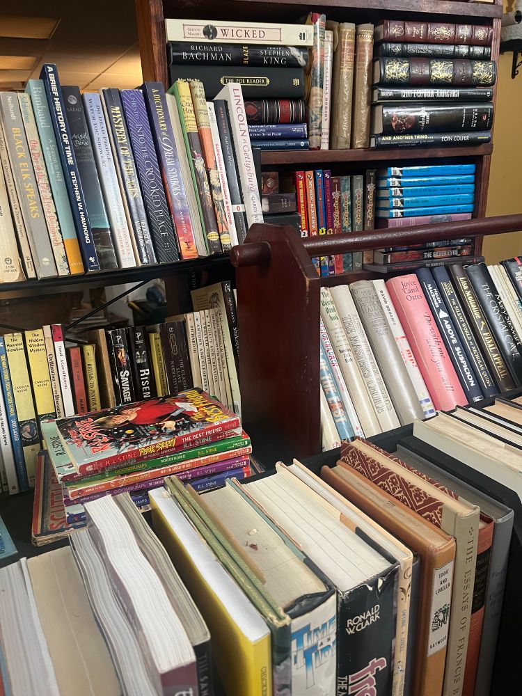Photo of stacks of books conveniently displayed for live stream and ready for sale!
