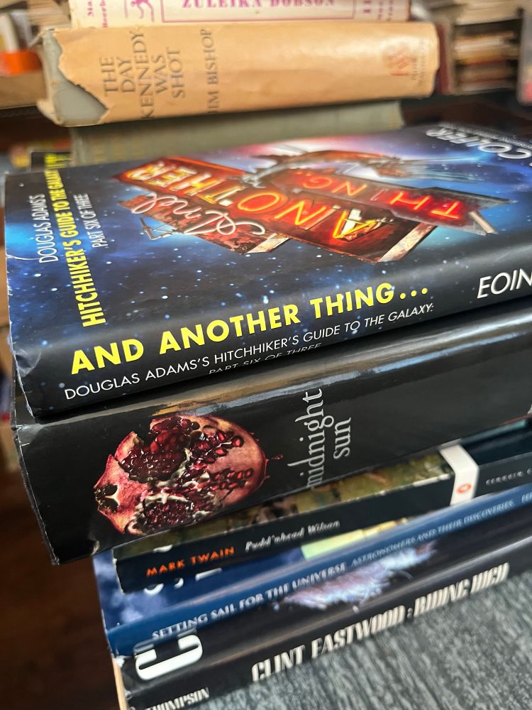 Stack of awesome books including a book from the Hitchhikers Guide to the Galaxy series and other goodies!