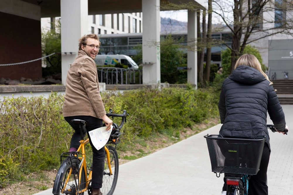 Two people riding bikes on an urban pathway
