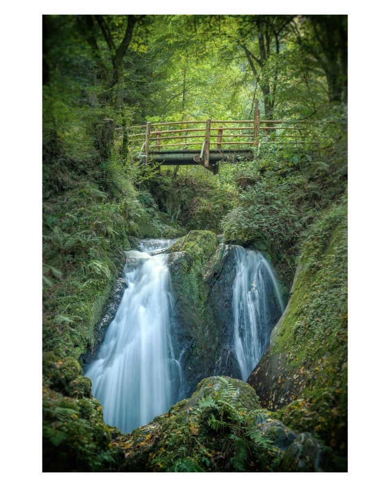 A picture of a waterfall with a bride above it.
