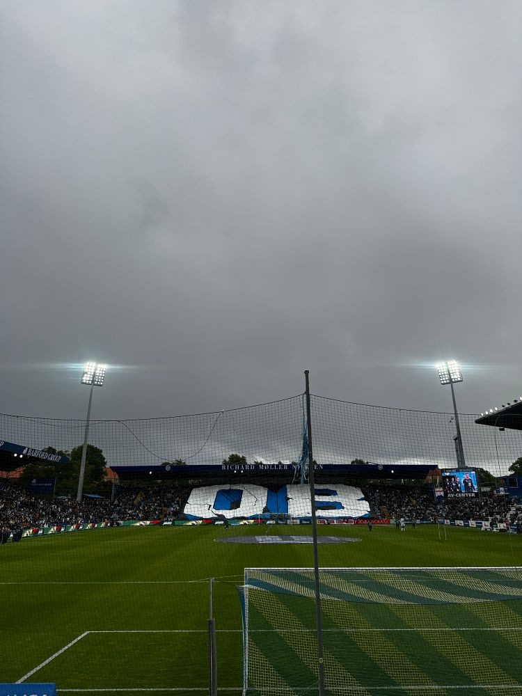 Dark clouds in the sky over a football stadium.