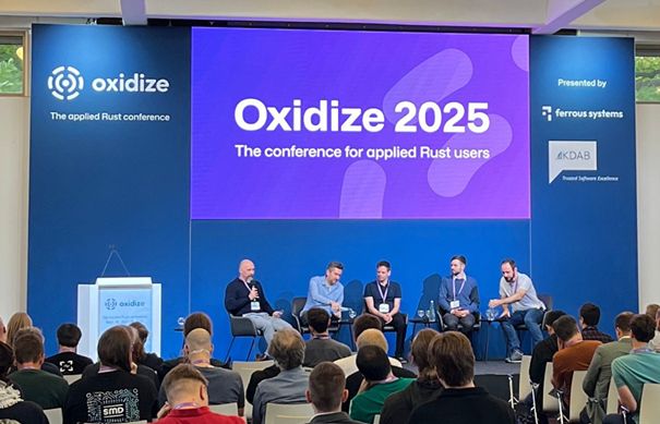 An image showing the cast of the panel “Rust and C++ can work together!” at Oxidize 2025. Showing from left to right Till Adam (KDAB), Stefan Nürnberger (Veecle), Olivier Goffart (Slint), Leon Matthes (KDAB) and Nicolas Fella (KDE).