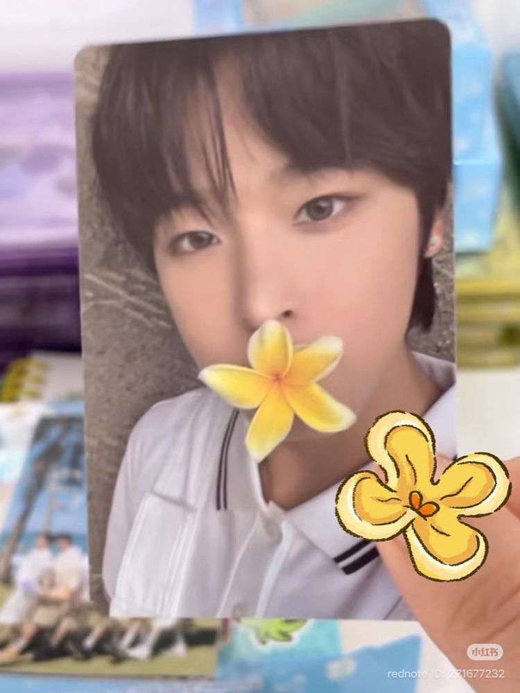 nct wish riku pc from colors album. riku is wearing a white shirt and has a yellow pua in his mouth