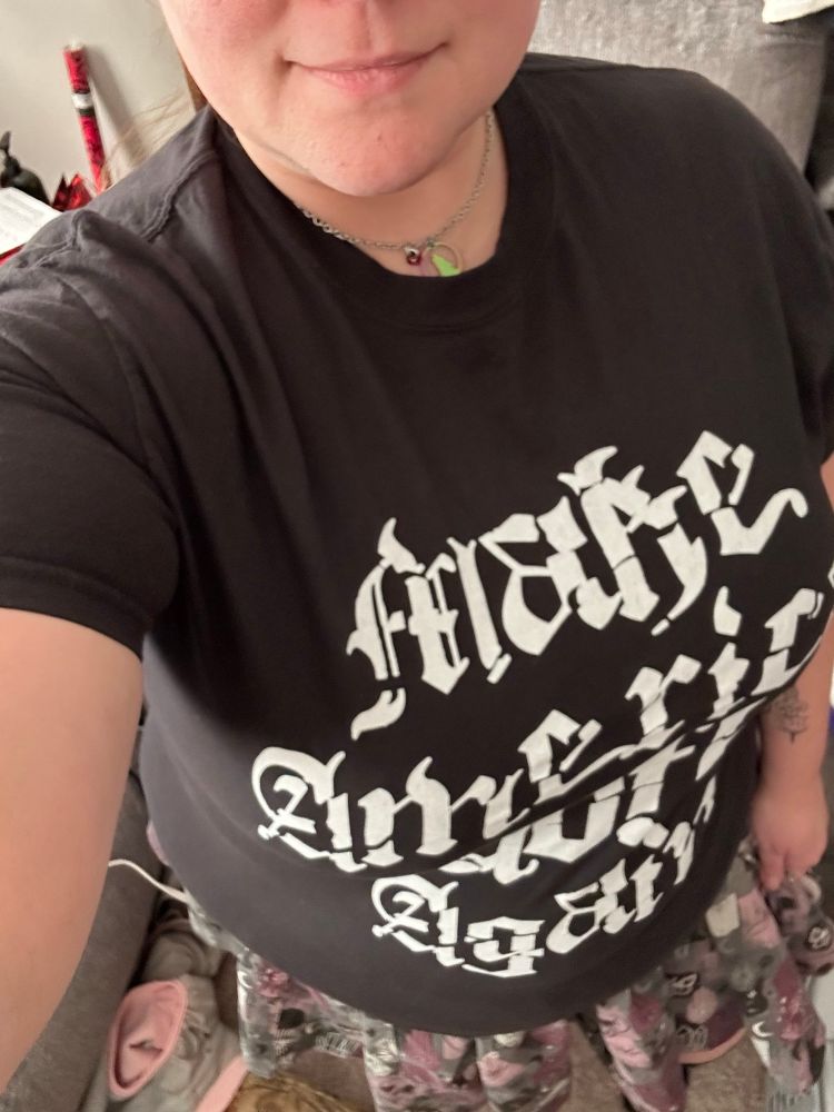 The author sporting a black tee shirt with white fancy text- “Make America Goth Again”