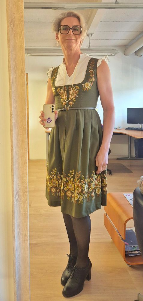 Robe type dirndl, verte olive avec des fleurs brodées dans dans tons brun dorés, longueur au genoux.