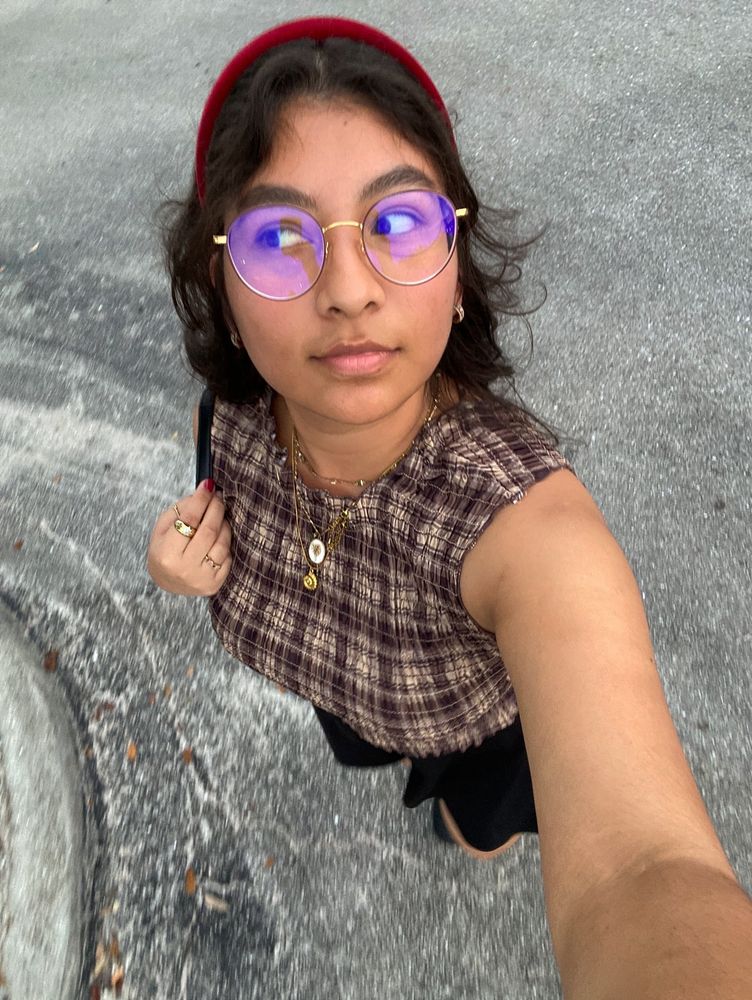 wide lens selfie picture from high point of me walking on the street to show off my outfit. Brown checkered pattern sleeveless top, black mini skirt, and black knee length pleather boots. 