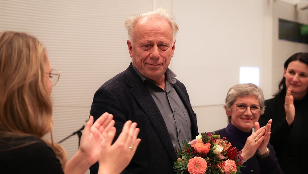 Auf dem Foto sind von links nach rechts Katharina Dröge, Jürgen Trittin, Britta Haßelmann und Irene Mihalic zu sehen. Jürgen Trittin hält einen Blumenstraß in der Hand. Die anderen klatschen.