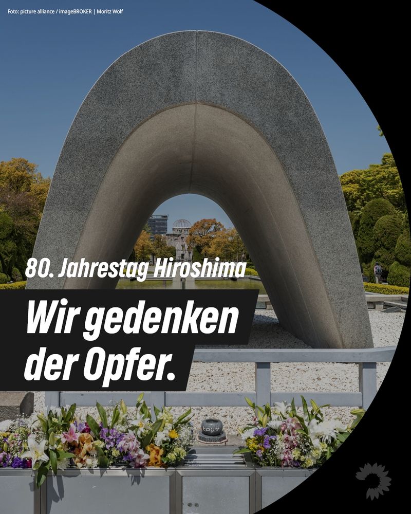 Gedenkfoto zum 80. Jahrestag des Atombombenabwurfs auf Hiroshima. Im Zentrum der Grafik ist das Friedensdenkmal im Hiroshima Peace Memorial Park zu sehen, davor ein Blumenarrangement. In weißer Schrift oben steht: „80. Jahrestag Hiroshima“. In einem schwarzen Balken mittig unten steht in weißer, fetter Schrift: „Wir gedenken der Opfer.“ Unten rechts ist das stilisierte Blumen-Logo der Grünen Bundestagsfraktion zu erkennen.