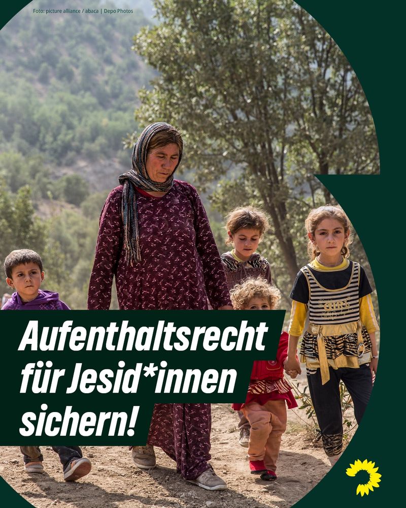 Zu sehen ist das Foto einer jesidischen Mutter mit ihren vier Kindern, die draußen auf einer sandigen Fläche laufen. Darauf steht geschrieben: „Aufenthaltsrecht für Jesid*innen sichern!