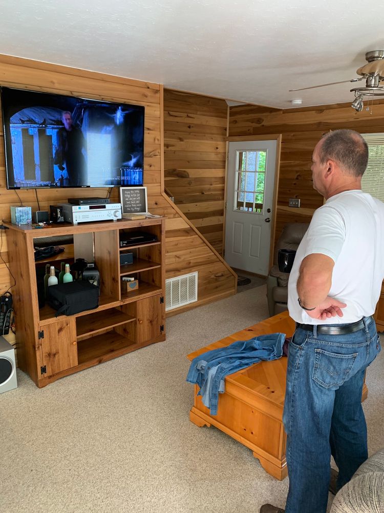 Dad with hands on hips standing 5 feet away from the TV