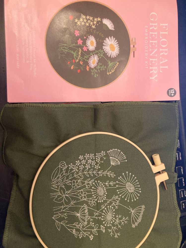 Left : Front cover of an embroidery kit 
Right: green fabric on an embroidery hook with white markings for the pattern 