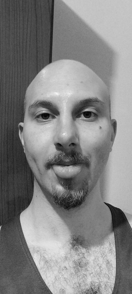 selfie homem careca mostrando a linguinha com um bigode e um tico de cavanhaque 