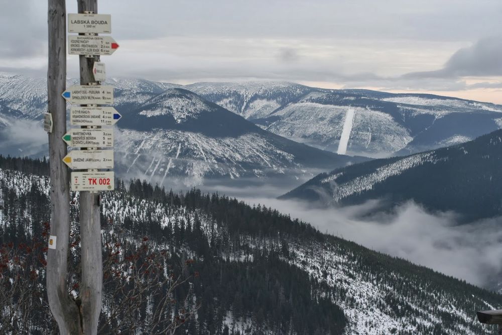 A sign indicating Labske Bouda at the source of the Elbe in a snowy landscape.