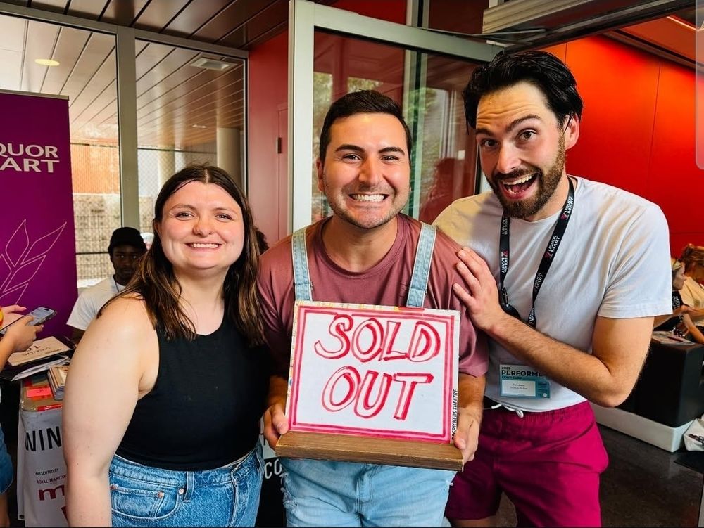 Patricia, chase and Chris hold a sign saying SOLD OUT. They are smiling!! 
