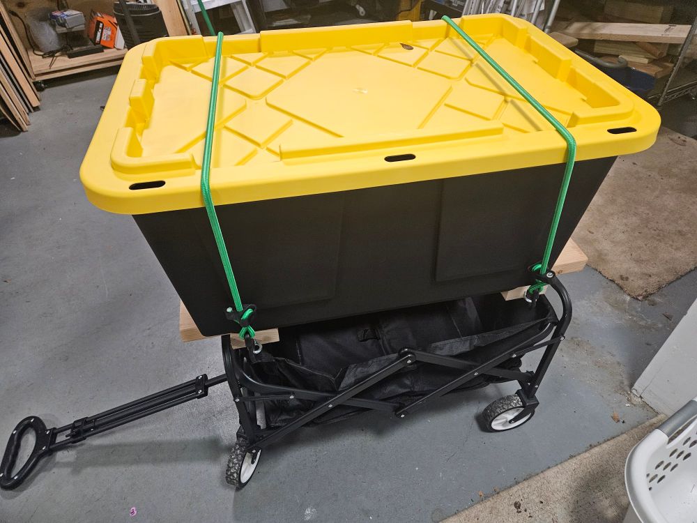 The cart and the shelf showing how we bungee corded a tubby of stuff to transport it since it is too large to fit in the cart. The bungee cords keep the tubby secure and the shelf allows for space underneath as well as moving big things. 