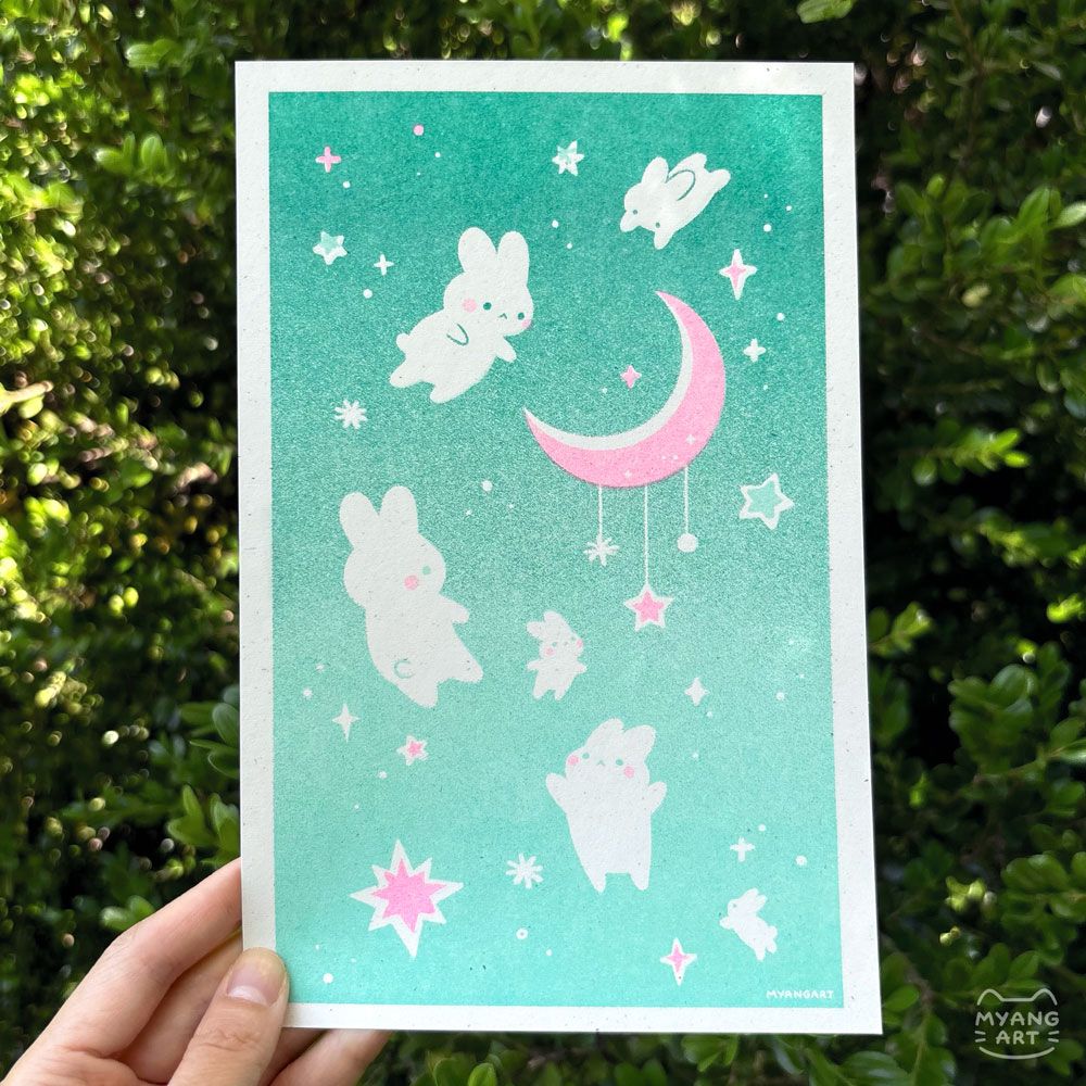 Risograph print in a simple style of white bunnies floating on a mint background. They are reaching toward a pink moon located center right. There are white and pink stars scattered throughout the background. Inks used are mint, turquoise, and fluorescent pink. 