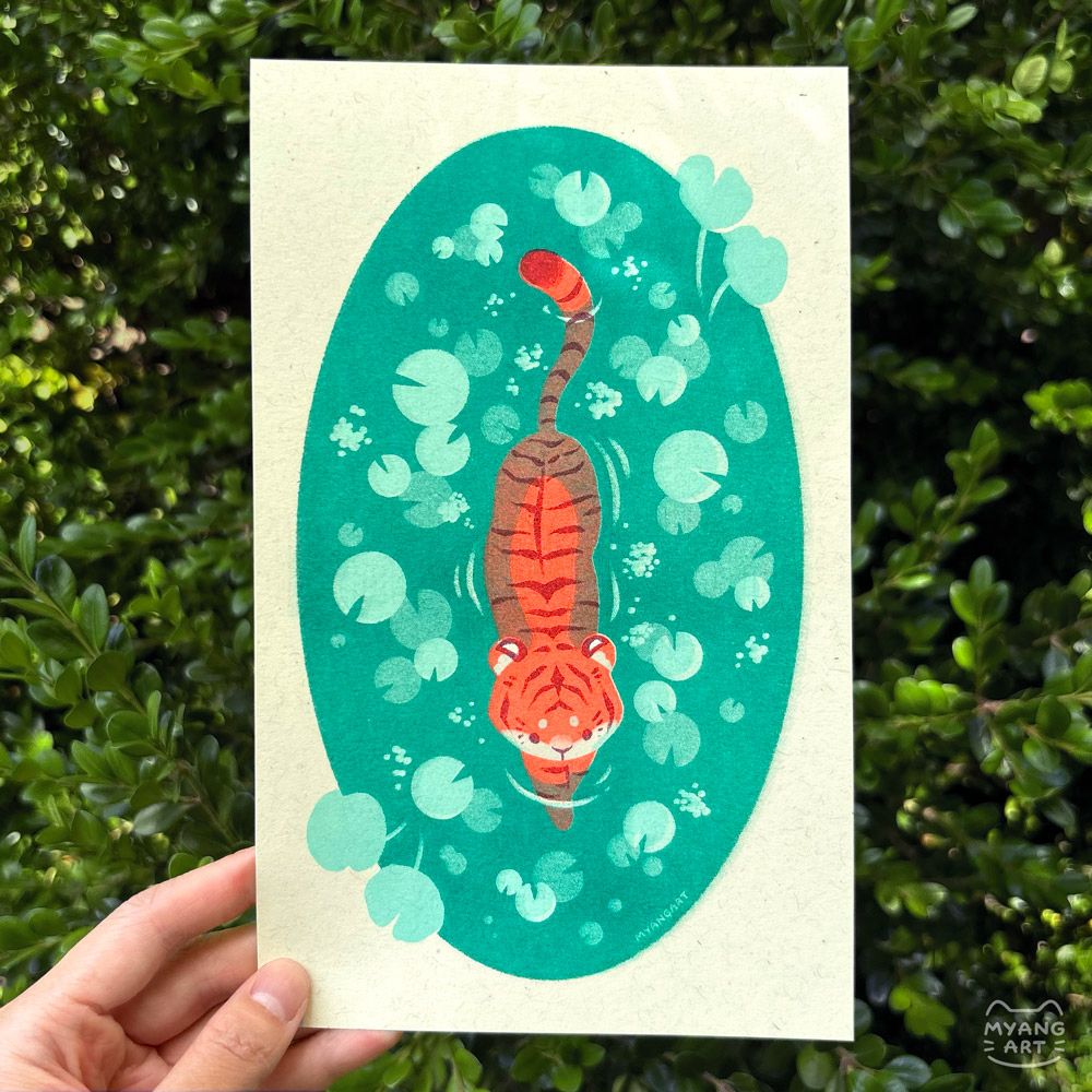 Risograph print of a tiger in the middle of an oval shaped lily pond. The pond is isolated on the page, similar to a spot illustration. The viewer sees the tiger from above, half submerged in the water and taking a step forward. There are lily pads scattered over the water, with a couple breaching the pond edges on the top right corner and bottom left corner. Inks used are fluorescent orange, mint, turquoise, and maroon.