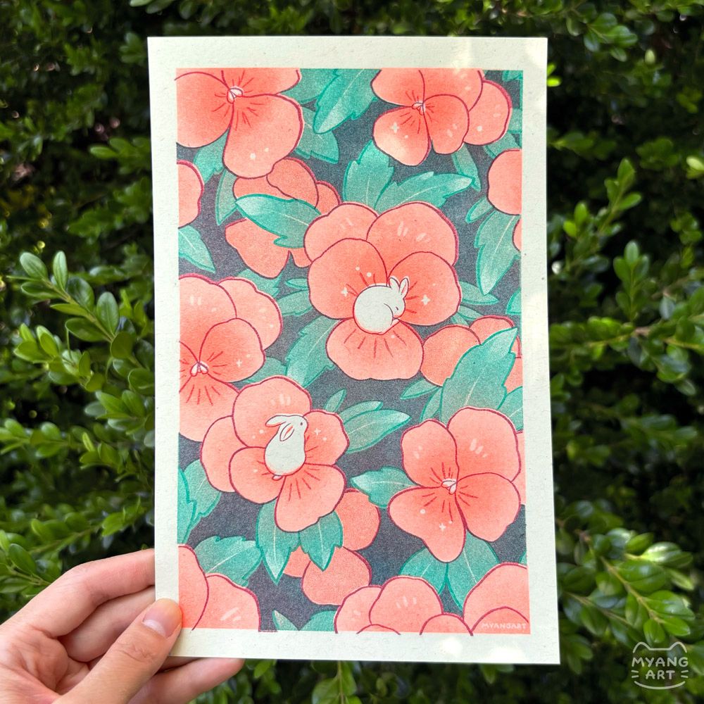 Risograph print of an illustration featuring orange nasturtium flowers filling the page, with two white bunnies resting on top. One is curled up sleeping on a flower and the other is observing from another flower. Inks used are fluorescent orange, maroon, and turquoise.
