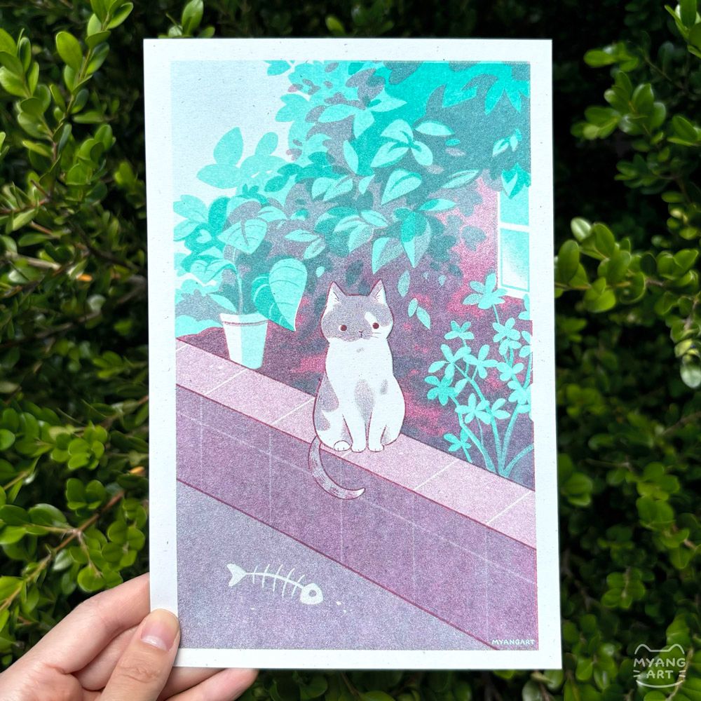 Risograph print of a cat politely sitting on a stone wall, in front of a house with a garden. A skeleton of a fish lies in the bottom left corner. This was printed in mint, turquoise, and maroon ink. 