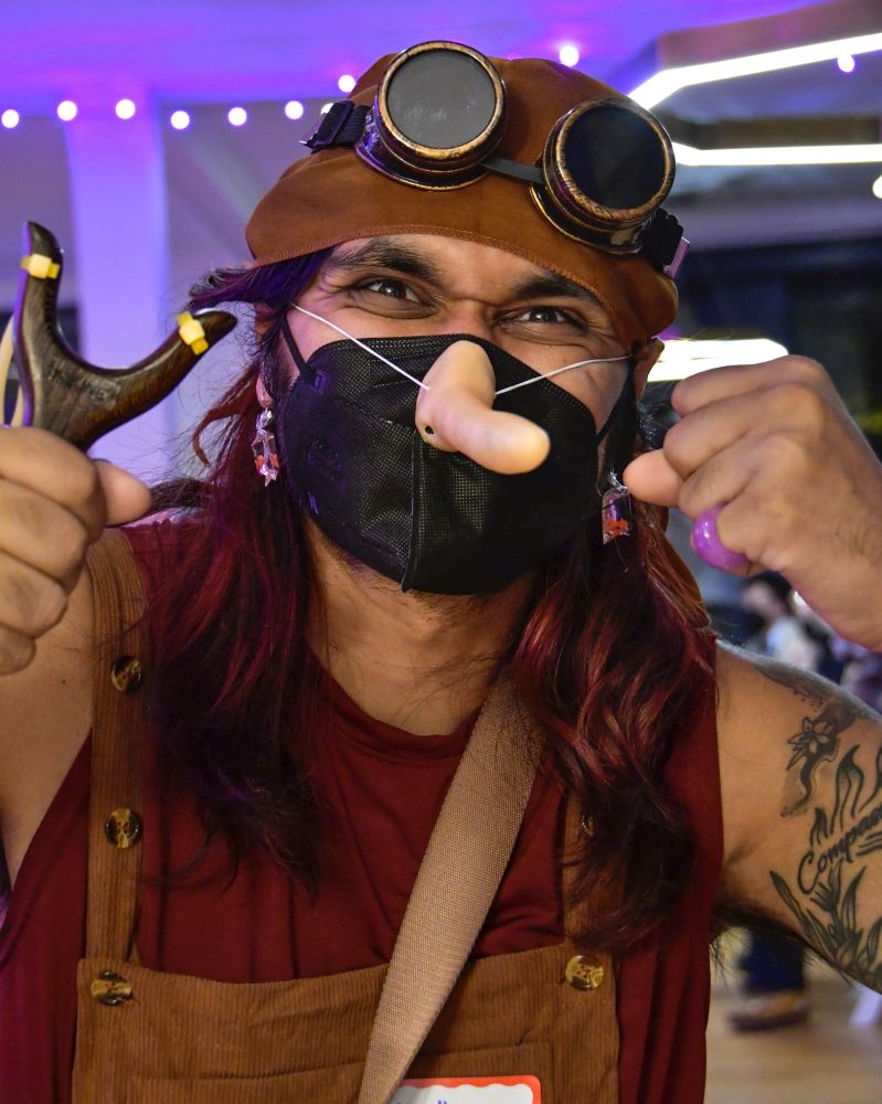 Mustafa Awar, wearing a long nose over a black KN95 and costume, made an angry face when posed for Julie Lam to support MaskTogetherAmerica 
