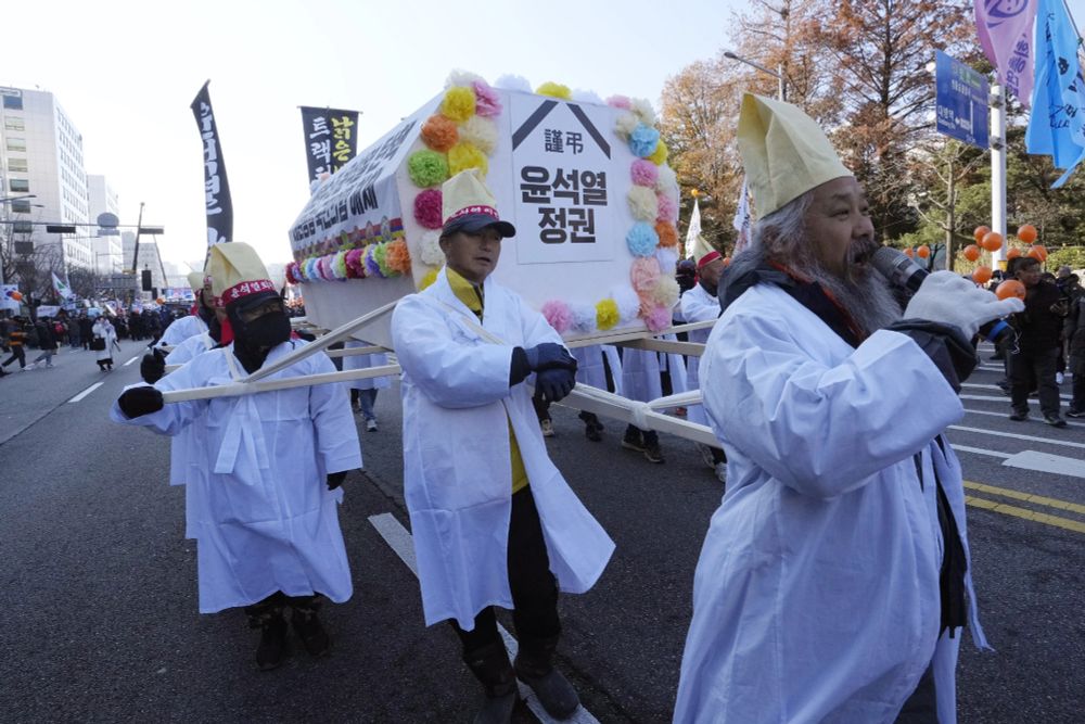 Farmers carry a coffin symbolizing South Korean President Yoon Suk Yeol’s government before a rally to demand his impeachment outside the National Assembly in Seoul, South Korea, Saturday, Dec. 14, 2024. The signs read " Yoon Suk Yeol’s government. " (AP Photo/Ahn Young-joon)