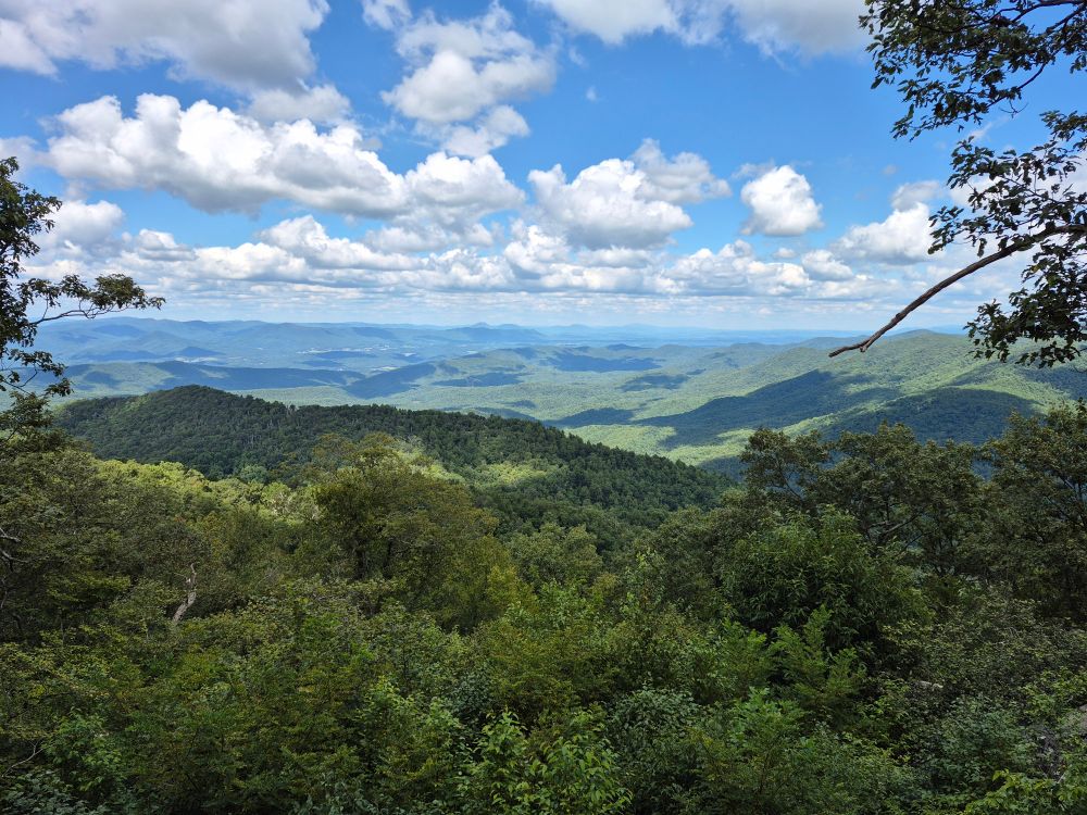 A distant view of mountains under a brilliant blue sky peppered with clouds