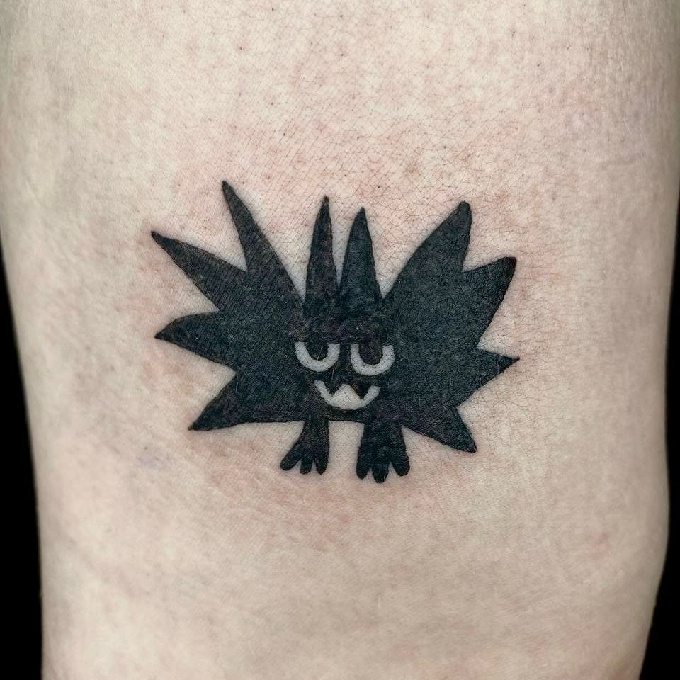black freshly done tattoo of a simplistic bat creature on white skin 