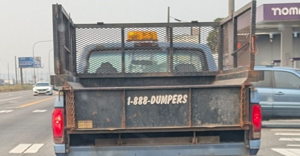Back of a pickup that says 1-888-DUMPERS