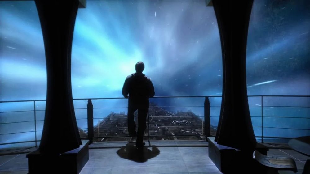 A man is in the center of the image, although he is mostly just a dark silhouette. He is standing on the bridge of some kind of space ship, facing a viewing window that looks out into space with the front of the ship barely visible, jutting forward below him. Around the ship is a field of stars overlaid with colored streaks similar to an aurora: a frame of faster-than-light travel caught in motion. This image is a still from the last episode of Stargate Universe, "Gauntlet", when Eli (played by David Blue) is the last member of the crew not in a stasis pod. We don't know if he's going to find a solution to surviving the long trip between galaxies without a stasis pod.