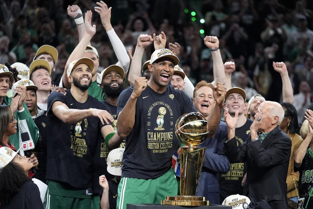 Les celtics exultent devant le trophée le soir où ils ont gagné leur titre NBA