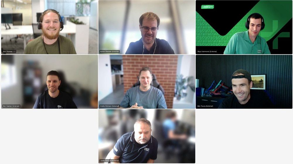 Veeam 100 ANZ team virtual meeting featuring seven participants in a video call. The team members appear engaged, with some smiling and others in discussion. The Veeam-branded background is visible in one participant's frame, reinforcing the team's affiliation. This image highlights collaboration among Veeam's Australia and New Zealand (ANZ) community.