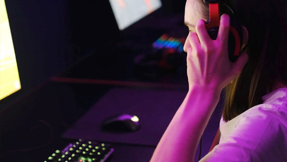 A law enforcement professional investigating a case looks at a computer screen while wearing headphones